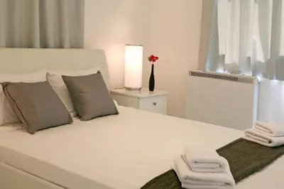 a bedroom with a white bed with towels on it at Corina Suites & Apartments in Limassol