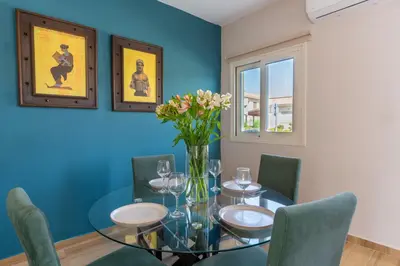 a dining room with a glass table and chairs at Modern Townhouse with pool ten minutes Limassol Center in Limassol
