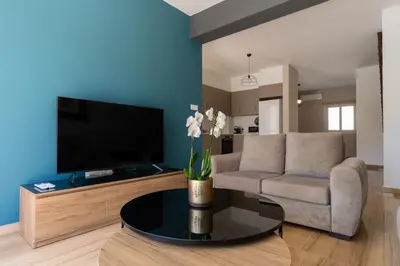 a living room with a couch and a tv at Modern Townhouse with pool ten minutes Limassol Center in Limassol