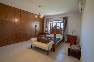 a bedroom with a bed and a chair and a window at Aέναη in Pyrga