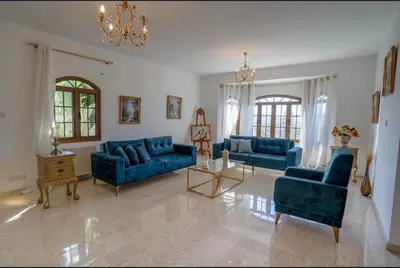 a living room with blue couches and a chandelier at Aέναη in Pyrga