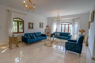 a living room with blue couches and a chandelier at Aέναη in Pyrga