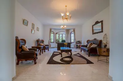 a living room with chairs and a table on a rug at Aέναη in Pyrga