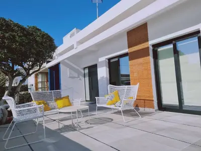 a group of white chairs with yellow pillows on a patio at Limassolian vibe house in Limassol