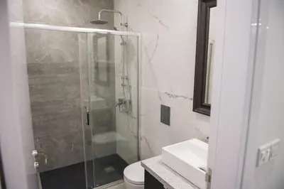 a bathroom with a shower and a toilet and a sink at STAY Urban Skin Suite in Nicosia