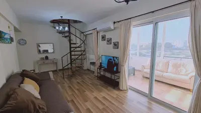 a living room with a couch and a sliding glass door at STAY Sea and Salt Lake Panoramic View Apt in Larnaka