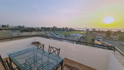 a balcony with a glass table and a view of the ocean at STAY Sea and Salt Lake Panoramic View Apt in Larnaka