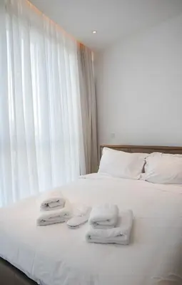 a bed with white towels on it with a window at 360 Luxury One Bedroom Suite in Nicosia