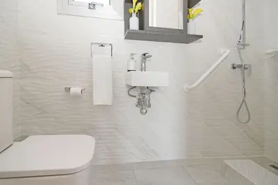 a white bathroom with a toilet and a shower at Thea Athena Villa - Walking to the Beach in Paralimni