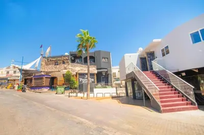 a city street with buildings and a palm tree at Marisa Napa Suites Ayia Napa in Ayia Napa