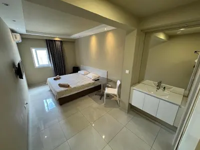 a small bedroom with a bed and a sink at Marisa Napa Suites Ayia Napa in Ayia Napa