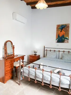 a bedroom with a bed and a desk and a mirror at Cozy Courtyard Apartment in Skarinou