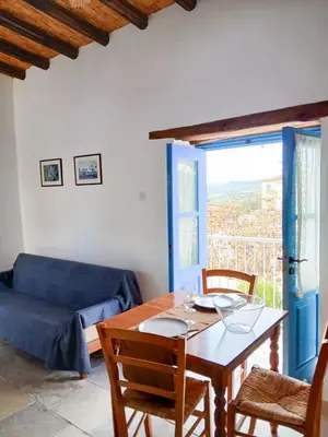 a living room with a table and a blue couch at Cozy Courtyard Apartment in Skarinou