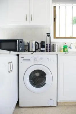 a kitchen with a washing machine and a microwave at Cavo Greco Oasis in Protaras