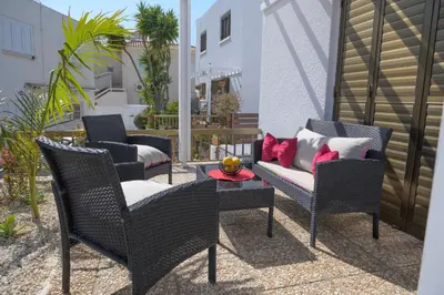 a patio with chairs and a table and a couch at Cavo Greco Oasis in Protaras
