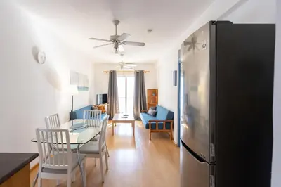 a kitchen and living room with a refrigerator and a table at Downtown apartment - Ayia Napa in Ayia Napa