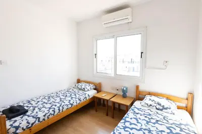 two beds in a room with a window at Downtown apartment - Ayia Napa in Ayia Napa