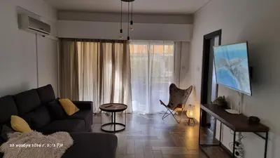 a living room with a couch and a table and a window at Deana beach in Limassol
