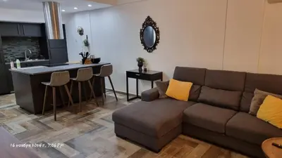 a living room with a couch and a kitchen at Deana beach in Limassol