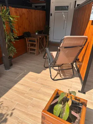 a chair sitting in a room with a potted plant at Cozzi Deluxe Studio in Voroklini