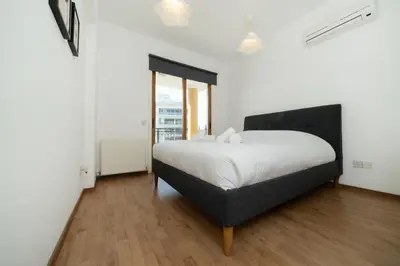 a bedroom with a bed with a black headboard at 1 bedroom flat in city center in Nicosia