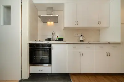 a kitchen with white cabinets and a black oven at 1 bedroom flat in city center in Nicosia