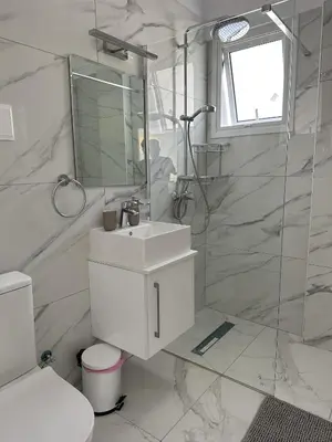 a white bathroom with a sink and a shower at Modern Seaside Retreat Near Nissi Beach in Ayia Napa
