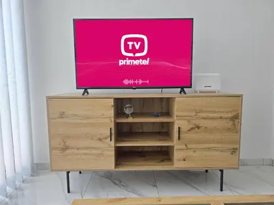 a flat screen tv sitting on top of a wooden entertainment center at Modern Seaside Retreat Near Nissi Beach in Ayia Napa