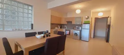 a kitchen and dining room with a table and a kitchen with a refrigerator at Pyla Gardens A104 in Pyla