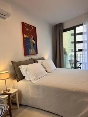 a bedroom with a large bed and a balcony at 9 Muses Holiday apartments in Larnaka