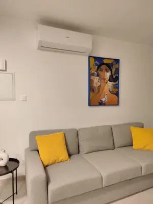 a living room with a couch with yellow pillows at 9 Muses Holiday apartments in Larnaka