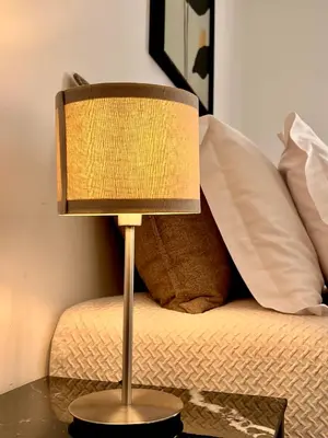 a lamp sitting on a table next to a bed at 9 Muses Holiday apartments in Larnaka