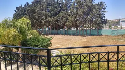 a fence in front of a yard with trees at Pyla Village Resort E108 in Pyla