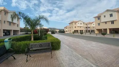 two benches sitting on a brick walkway next to buildings at Pyla Village Resort E108 in Pyla