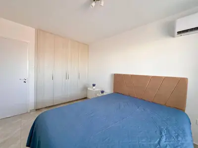 a bedroom with a blue bed and white cabinets at Stay With Oleg 102A in Paralimni