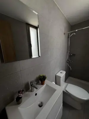 a bathroom with a sink and a toilet and a mirror at Rachel 401 in Larnaka