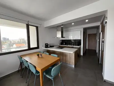a kitchen and dining room with a wooden table and chairs at Rachel 401 in Larnaka