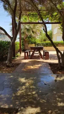 a picnic table in a park with trees at On the beachfront, AYIA THEKLA, AGIA NAPA MARINA in Ayia Napa