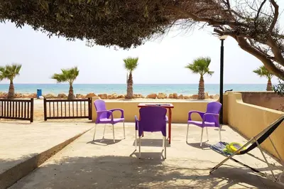 a table and chairs with the beach in the background at On the beachfront, AYIA THEKLA, AGIA NAPA MARINA in Ayia Napa