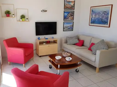 a living room with two couches and a tv at On the beachfront, AYIA THEKLA, AGIA NAPA MARINA in Ayia Napa