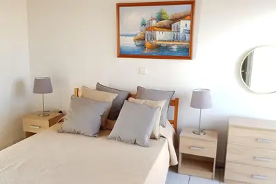 a bedroom with a bed and a painting on the wall at On the beachfront, AYIA THEKLA, AGIA NAPA MARINA in Ayia Napa