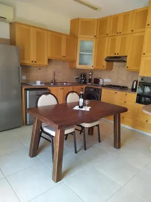 a kitchen with a table and two chairs and a refrigerator at The Tower Penthouse in Strovolos