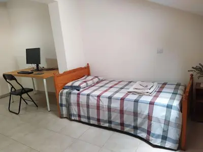 a bedroom with a bed and a desk with a computer at The Tower Penthouse in Strovolos