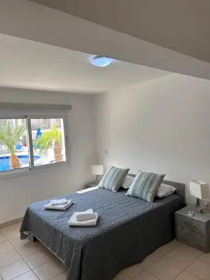 a bedroom with a bed with two towels on it at Beautiful 2 Bed Ground Floor Apartment With Pool in Paralimni