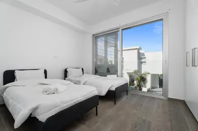 a bedroom with two beds and a large window at Levanda Hills Escape in Protaras in Paralimni