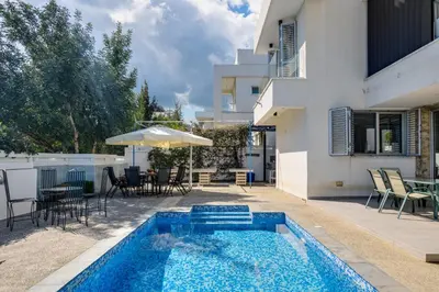 a swimming pool in front of a house at Levanda Hills Escape in Protaras in Paralimni
