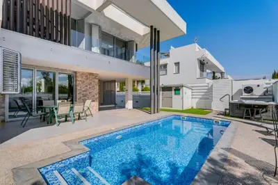 a swimming pool in the backyard of a house at Levanda Hills Escape in Protaras in Paralimni