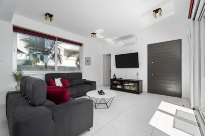 a living room with a couch and a tv at Levanda Hills Escape in Protaras in Paralimni