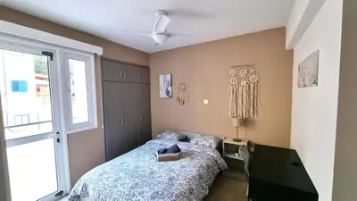a bedroom with a bed and a window at 2 Beachside Apts, 5min Walk to Shore with Internet in Larnaka