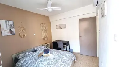 a bedroom with a bed and a ceiling fan at 2 Beachside Apts, 5min Walk to Shore with Internet in Larnaka